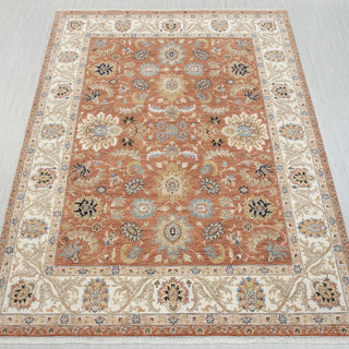 10x14 Rust hand-knotted rug in red cream teal with open floral design.