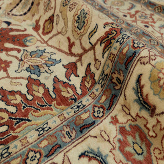 Hand-knotted wool rug featuring detailed floral and leaf motifs in ivory field with rust and teal accents, 6x9 ft.