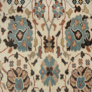 8x10 Hand-knotted wool rug featuring botanical pattern in ivory ground with blue, brown, tan accents.