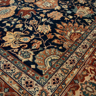 Persian-style hand-knotted rug with Mashad floral motifs in navy, camel, rust, and cream, room-size rug
