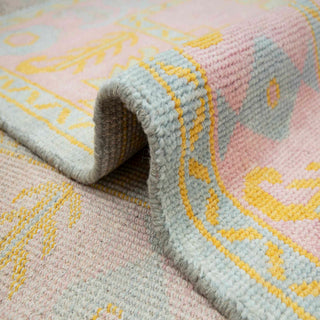 9X12 Turkish Oushak-style hand-knotted rug with tribal floral motifs in pink field, aqua and yellow accents