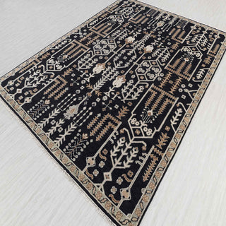 Anatolian kilim-style hand-knotted rug with graphic botanical motif in black, cream, warm brown.