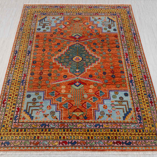 Caucasian-style hand-knotted rug in terracotta, teal, sky blue with geometric medallion design.