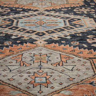 Caucasian-style hand-knotted rug with geometric medallion motif in charcoal, peach, ivory, and light blue