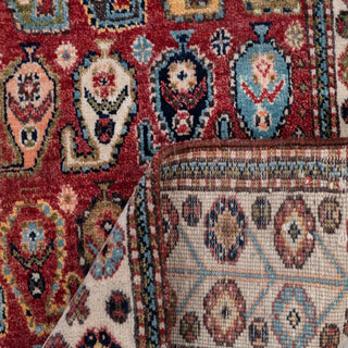 Caucasian-style hand-knotted rug with tribal boteh motif in rich red and multicolor accents.