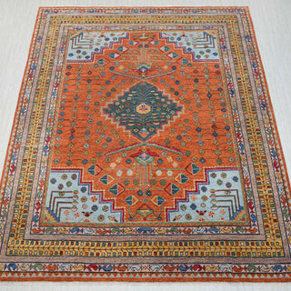 Hand-knotted 12x15 Persian tribal rug in terracotta orange rust field with striking navy blue diamond medallion center and geometric arrow motifs. Ivory cream accents, bold Southwestern tribal design, wool area rug for large living room dining space, durable low pile, natural dyes, easy maintenance