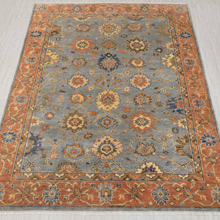 Hand-knotted rug in blue-grey and terracotta with traditional Oushak floral medallion pattern design.