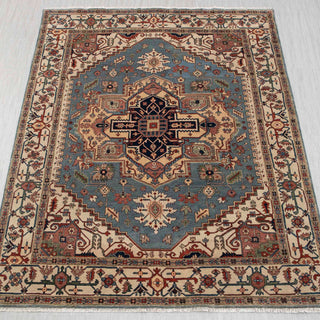 Hand-knotted rug in blue, ivory, and rust with large central medallion design, 9x12 area.