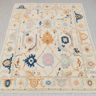 Hand-knotted rug in ivory with colorful Oushak floral and medallion design in navy, peach, blue, 9x12