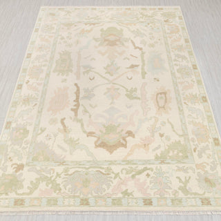 Hand-knotted rug in ivory with pastel green, sand, and blush Oushak floral design, 9x12 ft