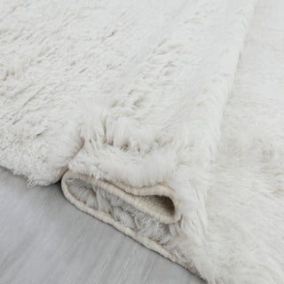 Hand-knotted rug in ivory with solid shag design and fringed edges, large cozy area size