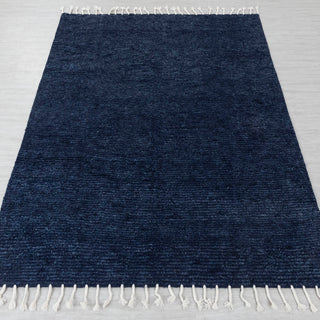 Hand-knotted rug in navy blue with solid textured design and white fringes, large size.

