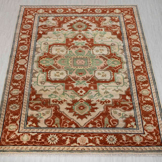 Hand-knotted rug in rust, ivory, and sage green with large geometric medallion design, 8x10.