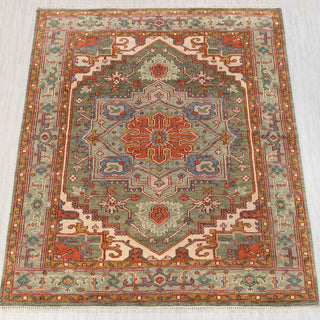 Hand-knotted rug in sage green, rust, and ivory with bold geometric medallion design, 8x10.