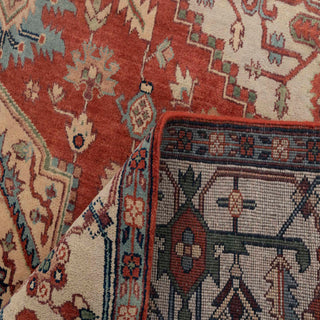 Hand-knotted wool area rug in rust, ivory, navy with detailed floral border, perfect 8x10 living room size.