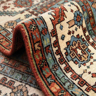 Hand-knotted wool area rug in rust with ivory border and blue accents, durable 8x10 size.