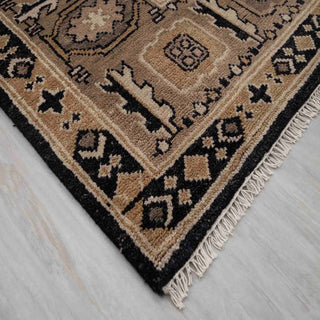 Hand-knotted wool area rug in versatile black and beige with patterned border, durable 8x10 living room size.