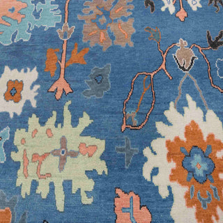 Hand-knotted wool rug featuring abstract floral Oushak pattern in navy, teal, coral, cream, orange, 8x10 size.