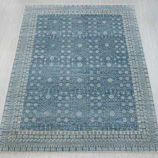Hand-knotted wool rug featuring all-over geometric floral pattern in turquoise blue, 8x10 size, low-pile durable."