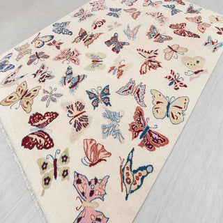 Hand-knotted wool rug featuring butterfly pattern in pink, blue, red, green, 9x12 living room size