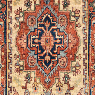 Hand-knotted wool rug featuring central Heriz medallion pattern in cream, terracotta, blue, 2.6x10.

