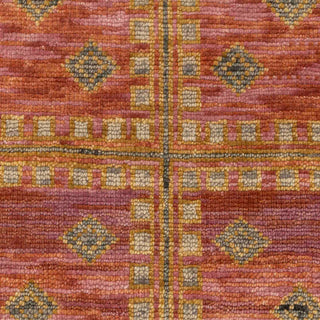 Hand-knotted wool rug featuring central tribal diamond pattern in rust, blush pink, gold, 8x10.