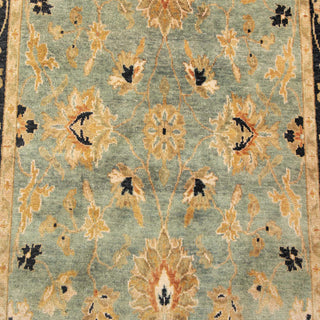 Hand-knotted wool rug featuring classic Persian floral pattern in green, beige, black border, 5x8