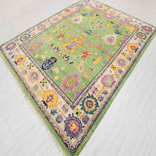 Hand-knotted wool rug featuring colorful Oushak motifs in lime green, lavender, gold, 8x10.