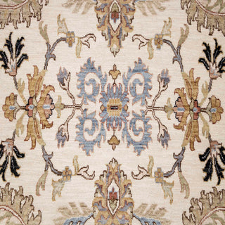 Hand-knotted wool rug featuring intricate allover floral pattern in ivory field with soft blue border, 10x14 ft