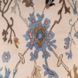 Hand-knotted wool rug featuring ivory field with blue and pastel floral motifs, bordered by light blue Oushak pattern, 8x10 size