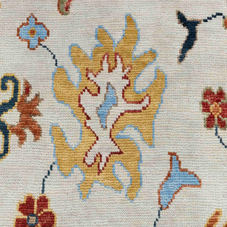 Hand-knotted wool rug featuring ivory field with multicolor floral Oushak motifs and teal, rust border, 8x10 area size