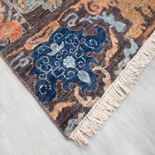 Hand-knotted wool rug featuring oversized palmette and floral motifs in blue, gold, and brown, 8x10.