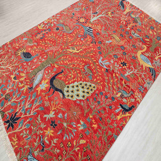Hand-knotted wool rug featuring peacocks, songbirds, and floral garden pattern in red, teal, gold, 6x9