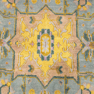 Hand-knotted wool rug featuring soft geometric medallion pattern in blush pink, teal, yellow, 9x12 ft.