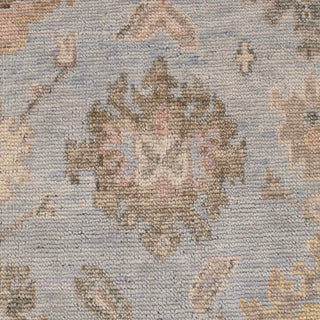 Hand-knotted wool rug featuring soft sky-blue field with pastel floral and vine motifs in beige, sand, blush, 8x10 size