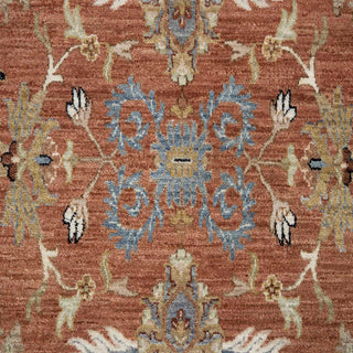 Hand-knotted wool rug featuring sparse floral pattern in rust navy cream, 10x14 size, low-pile durable.