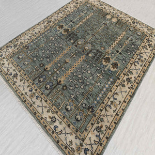 Hand-knotted wool rug featuring tree-of-life floral pattern in teal, ivory, gold, navy, 8x10 size