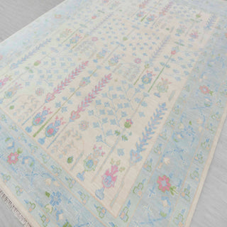 Hand-knotted wool rug featuring tree-of-life garden pattern in ivory, aqua, pink, green, 8x10 size