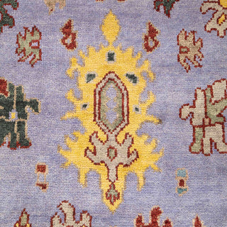 Hand-knotted wool rug featuring whimsical Oushak motifs in lilac, gold, red, teal, 8x10 size.

