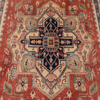 Heriz-style hand-knotted rug with bold geometric medallion and floral motifs in rust, navy, ivory.