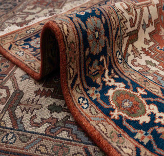 Heriz-style hand-knotted rug with tribal medallion motif in brick red, ivory, and dark blue, room-size 6x9 area.