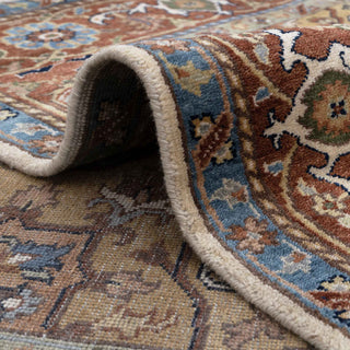 Heriz Serapi style hand-knotted rug with geometric medallion motif in rust, ivory, teal tones.