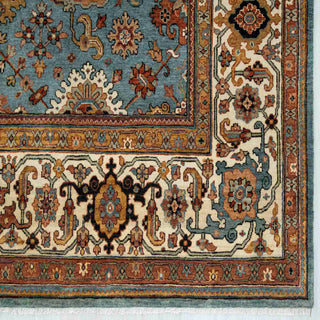 Modern classic hand-knotted rug with angular floral pattern in soft blue, terracotta, cream accents.
