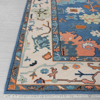 Modern hand-knotted rug with abstract blue Oushak pattern, cream border and colorful accents, ideal for bold designer interiors