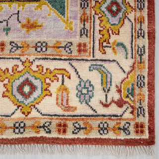 Modern hand-knotted rug with abstract geometric medallion pattern in rust, teal, gold, ivory.