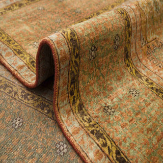 Modern hand-knotted rug with abstract geometric pattern in distressed green and rust colors.