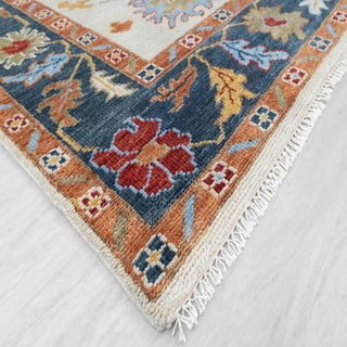 Modern hand-knotted rug with abstract ivory Oushak flowers, teal and rust accents, ideal for colorful boho interiors