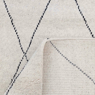 Modern hand-knotted rug with abstract linear diamond grid pattern in ivory, charcoal tones.