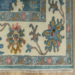 Modern hand-knotted rug with abstract teal Oushak flowers and ivory border, ideal for vibrant living rooms