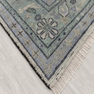 Modern hand-knotted rug with abstract tribal medallion pattern in gray, sage, soft blue.
